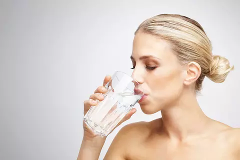 Frau trinkt ein Glas Wasser