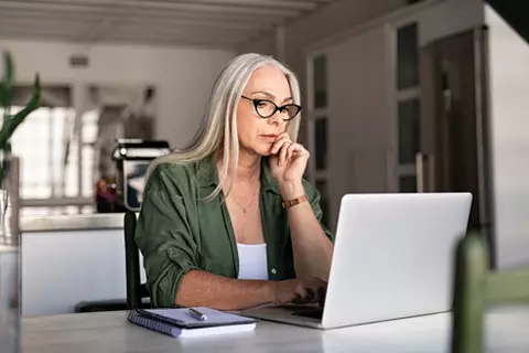 Frau sitzt vor Laptop
