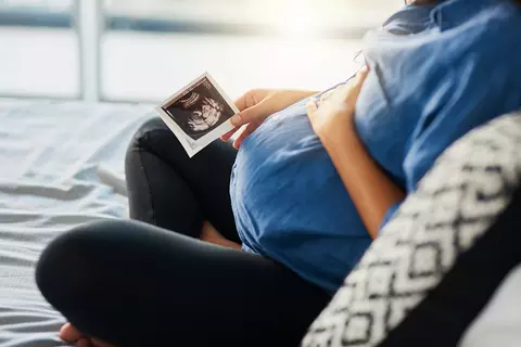 Schwangere hat ein Ultraschall-Bild in der Hand