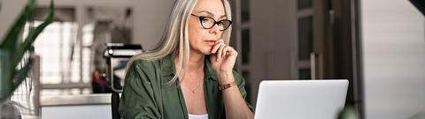 Frau sitzt vor Laptop