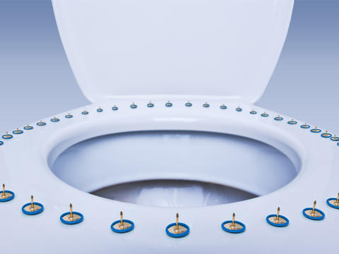 Toilettenbrille mit nach oben gedrehten Reißzwecken